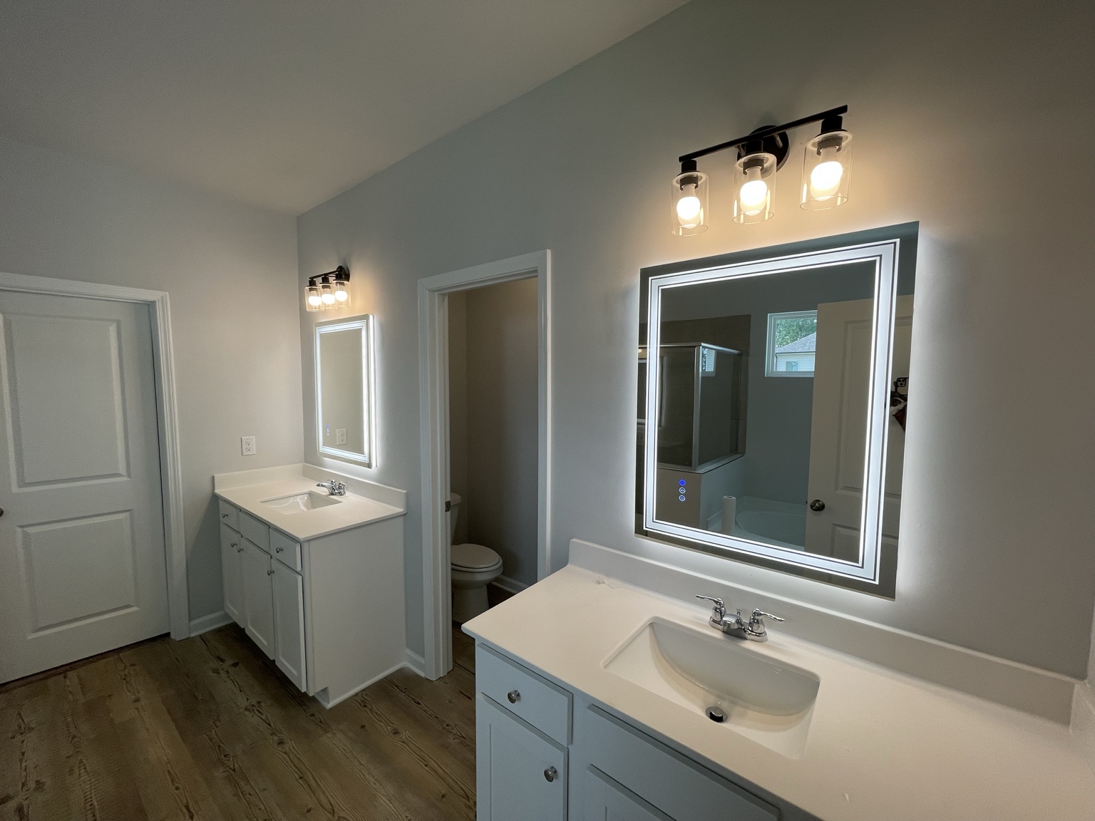 Clean finished bathroom vanities with lighted mirrors