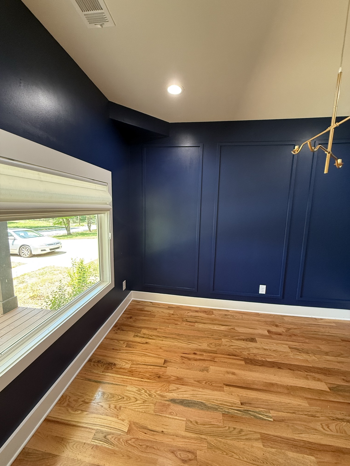 Finished navy accent room with clean trim and hardwood floors